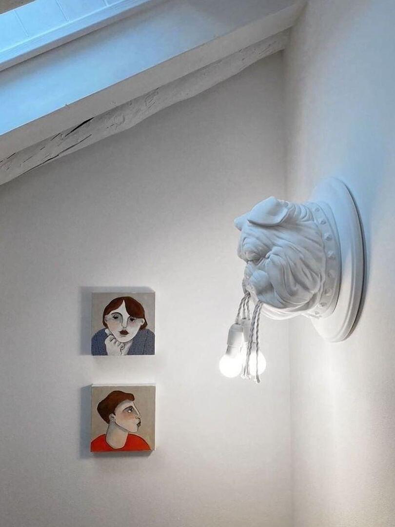 White bulldog wall fixture beside small framed pictures