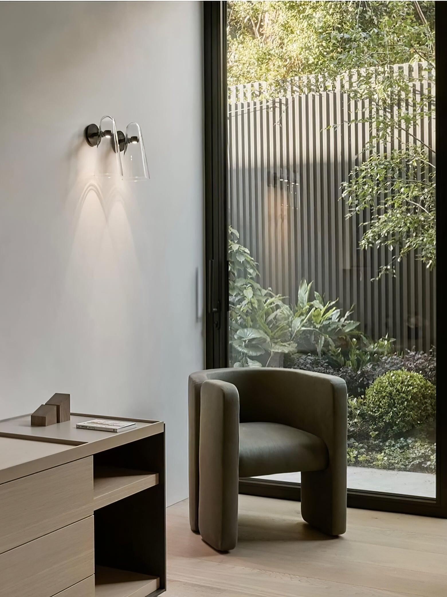 Small wall light above a wooden cabinet beside a garden window