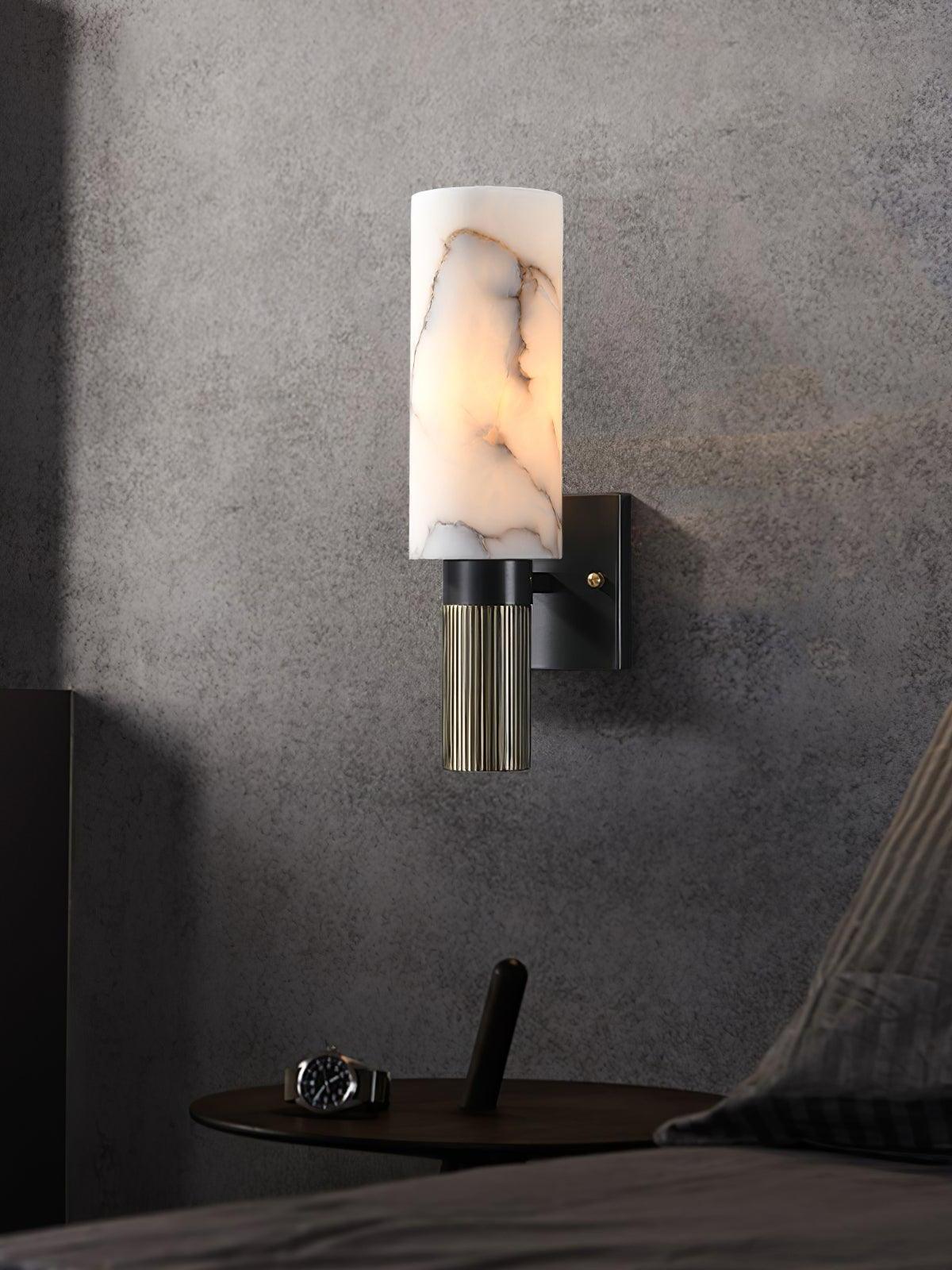 Torch marble sconce lit beside a bed