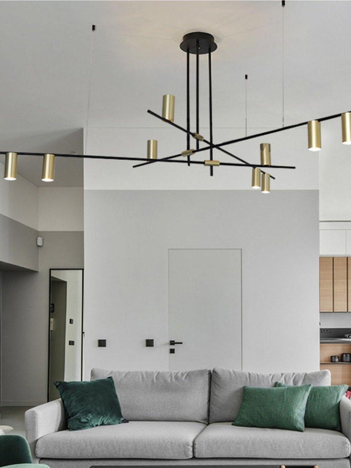 Open rod chandelier above a grey sofa
