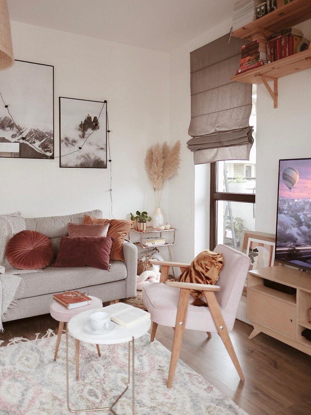 Partly cropped woven pendant above a living room with a sofa and wooden armchair