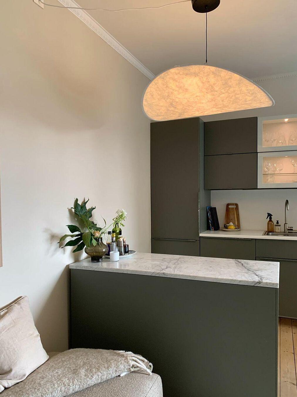 White curved pendant beside a green partition