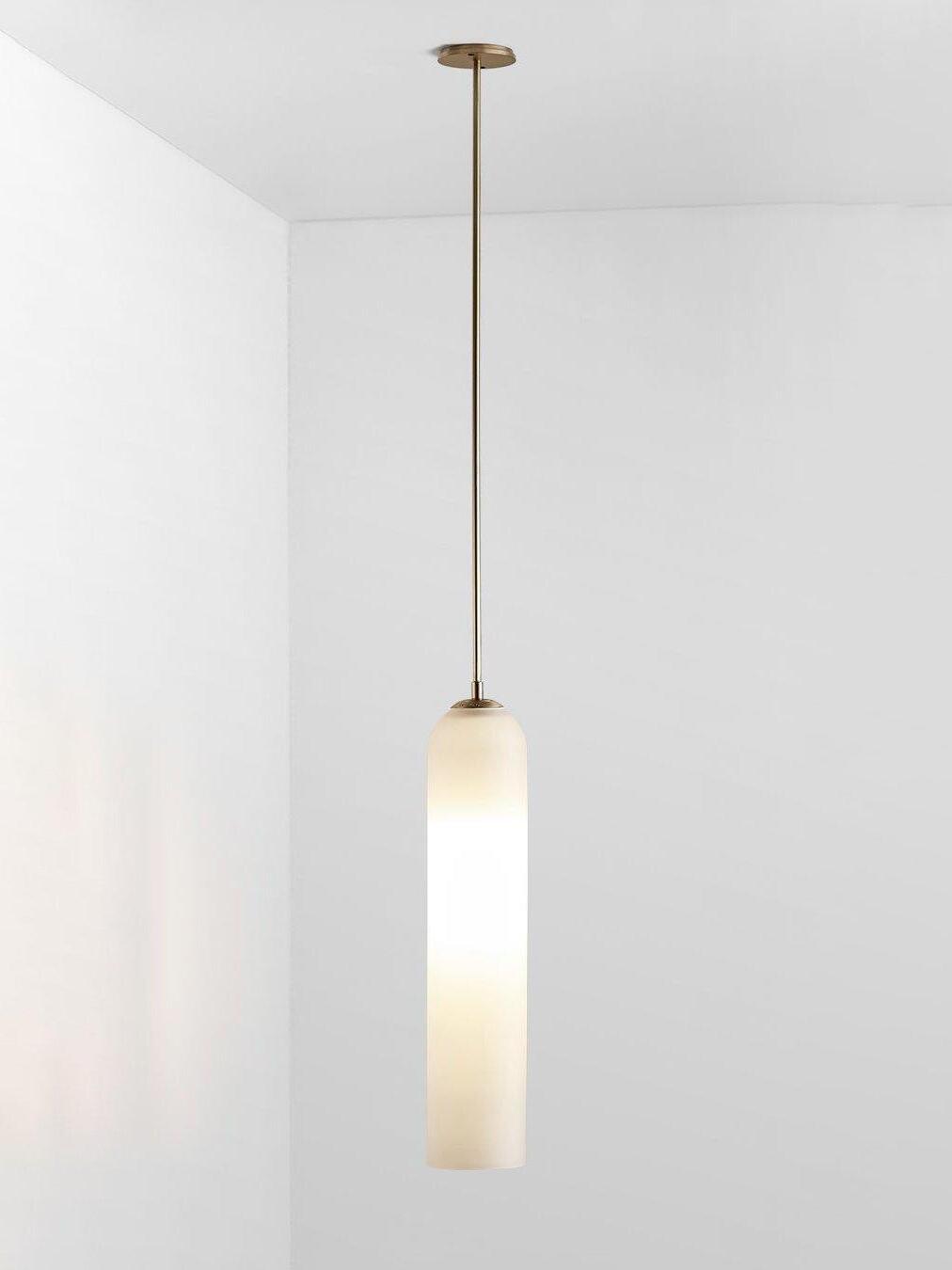 Illuminated glossy white glass Long Tube pendant with gold-toned straight rod and round ceiling canopy