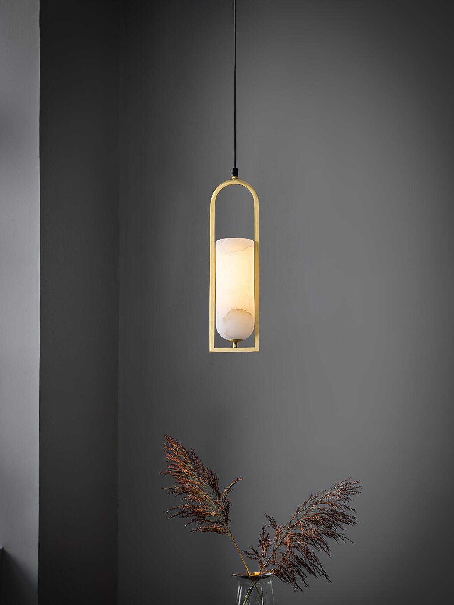 Melange pendant against a dark wall above a vase with dried foliage