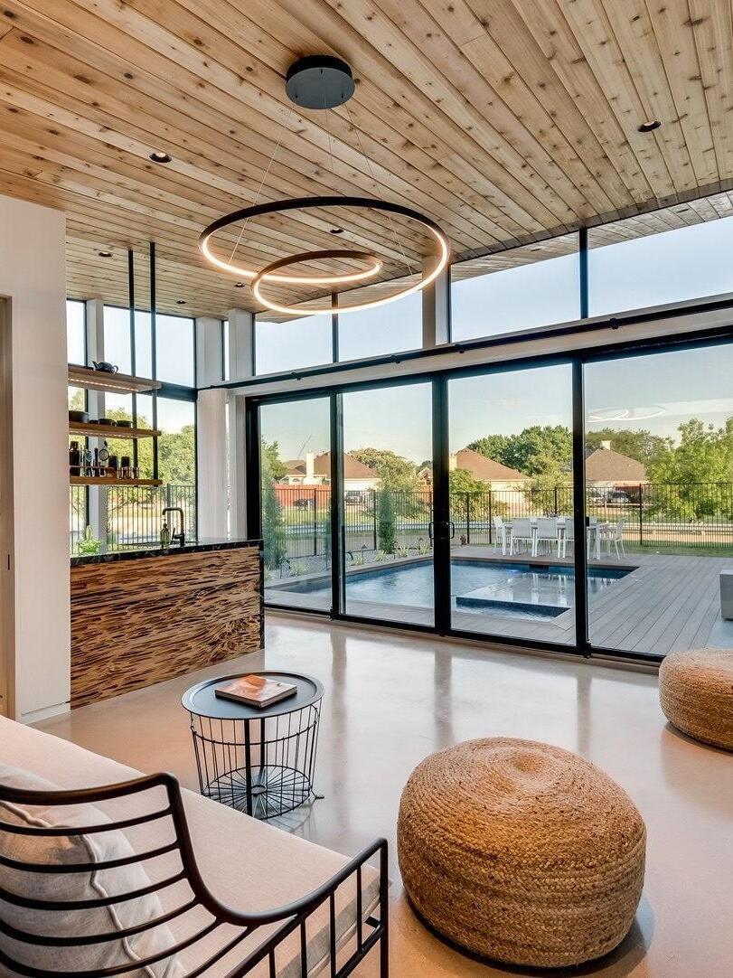 Black loop chandelier near tall windows and seating