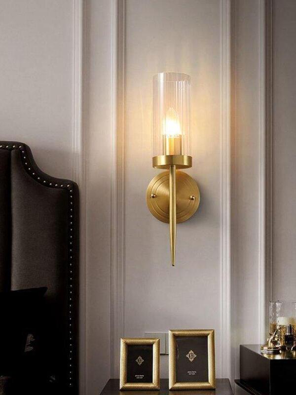 Single candle-style sconce above a bedside cabinet