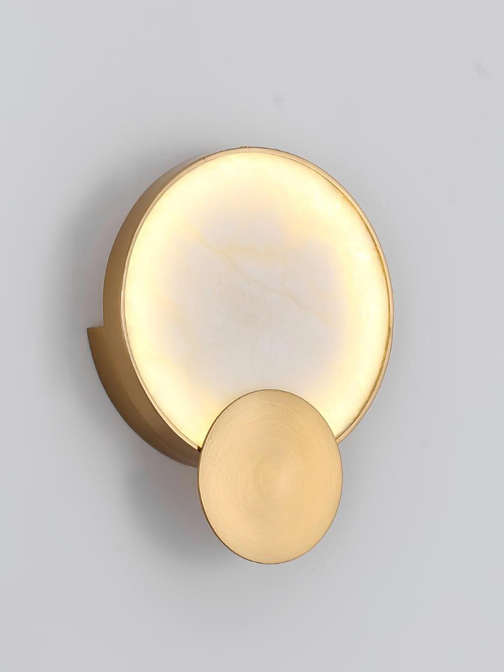 Lit round Terra Svet fixture against a pale wall