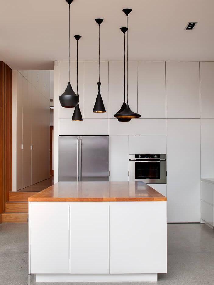 Three different black shades above a kitchen island