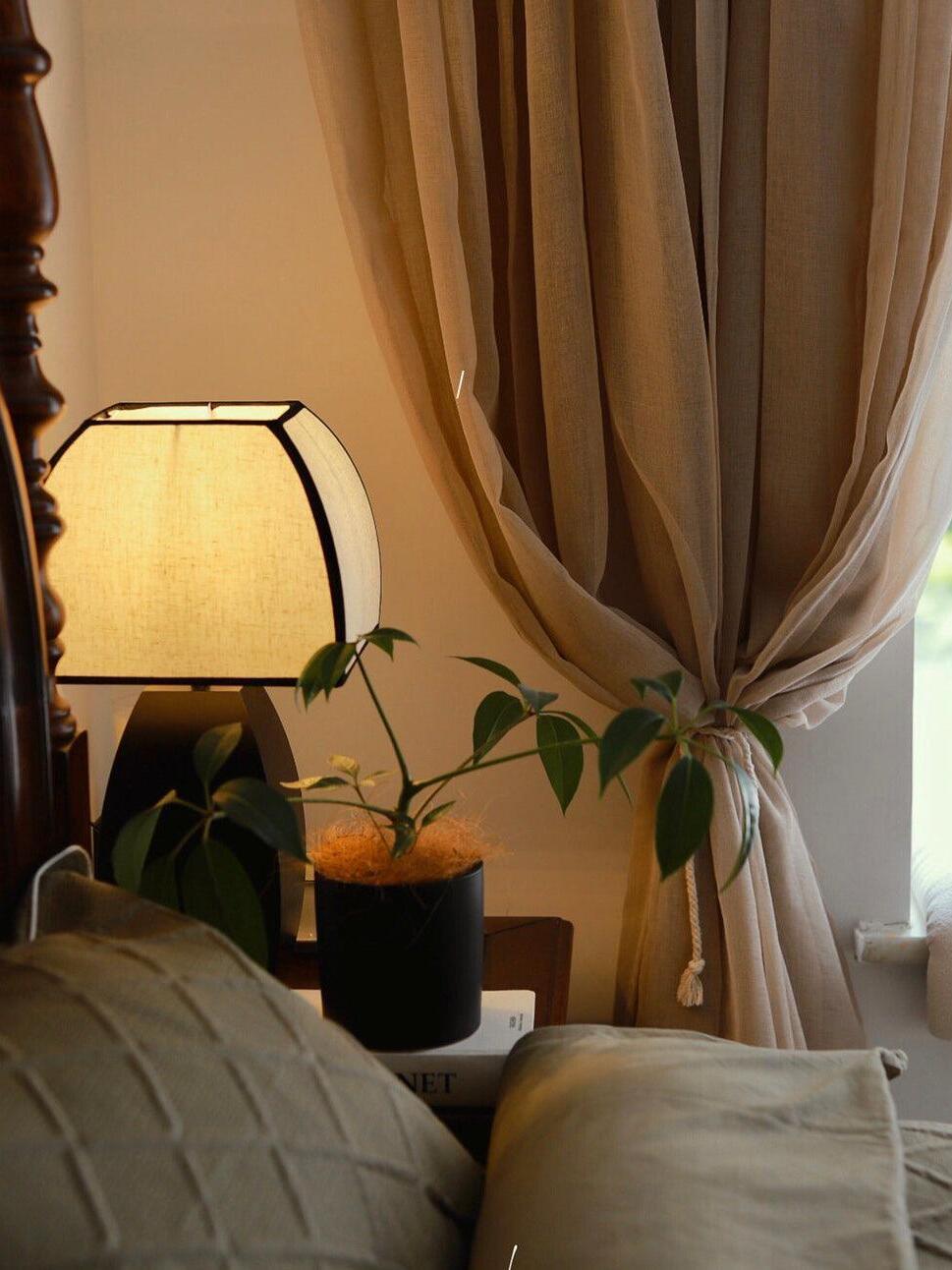 Lit Javier lamp by sofa and curtain