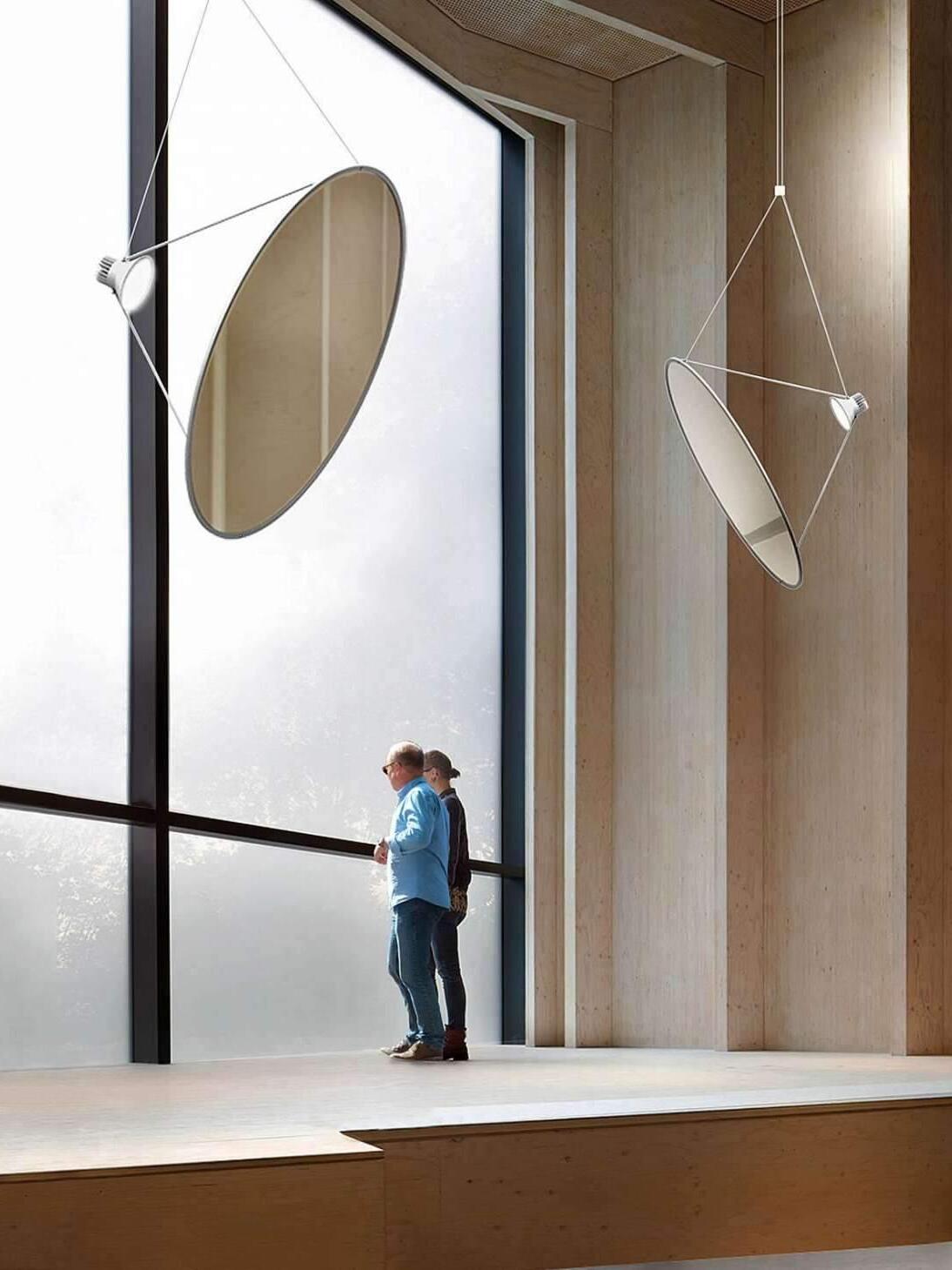 Reflective disc pendants near tall windows