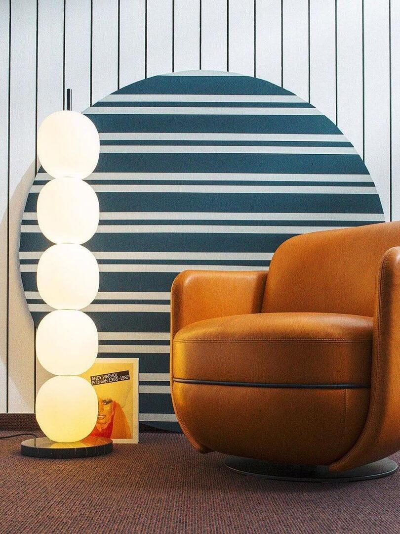 Five-globe lamp beside orange chair