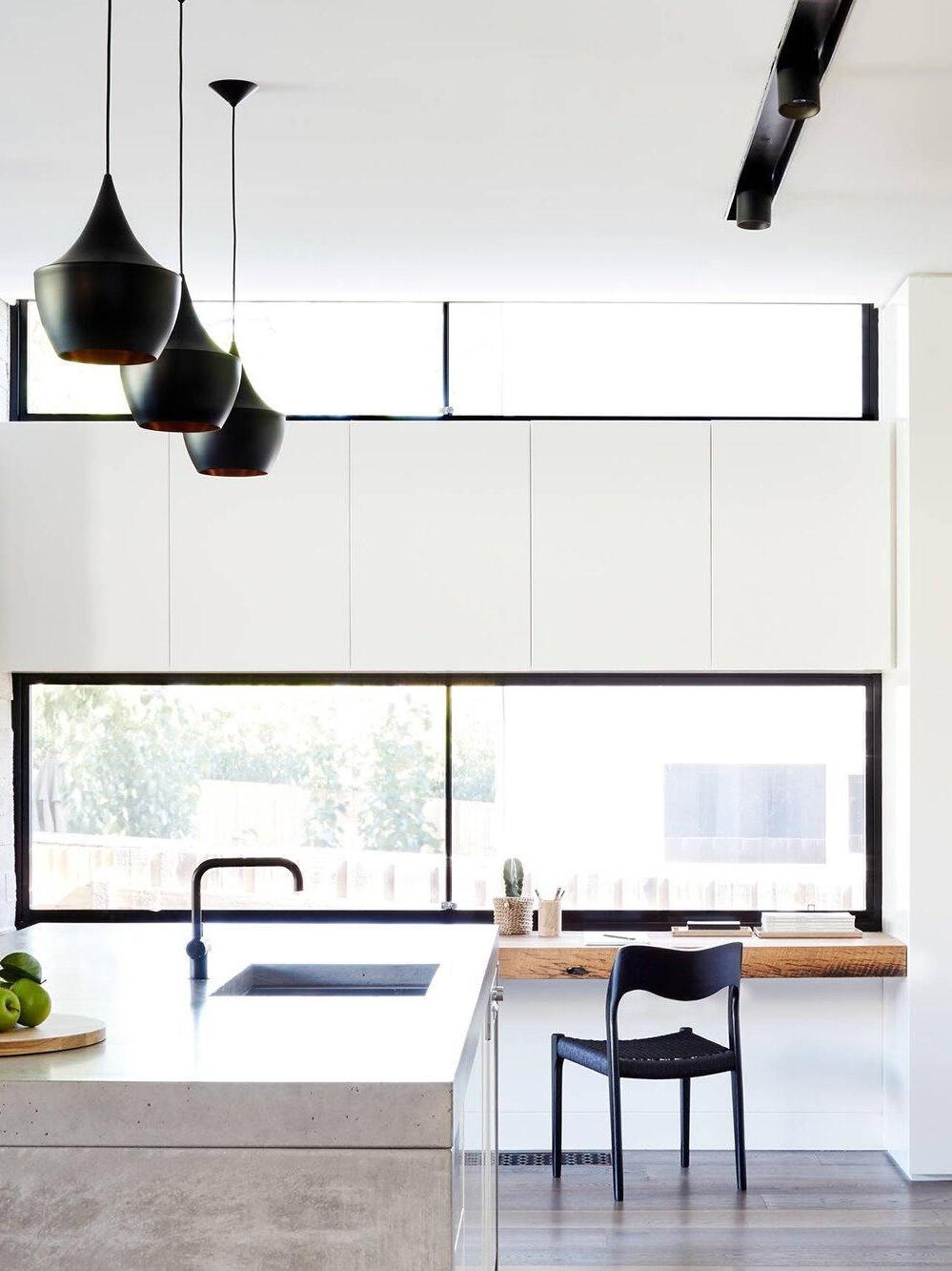 Black rounded pendant group beside a large window