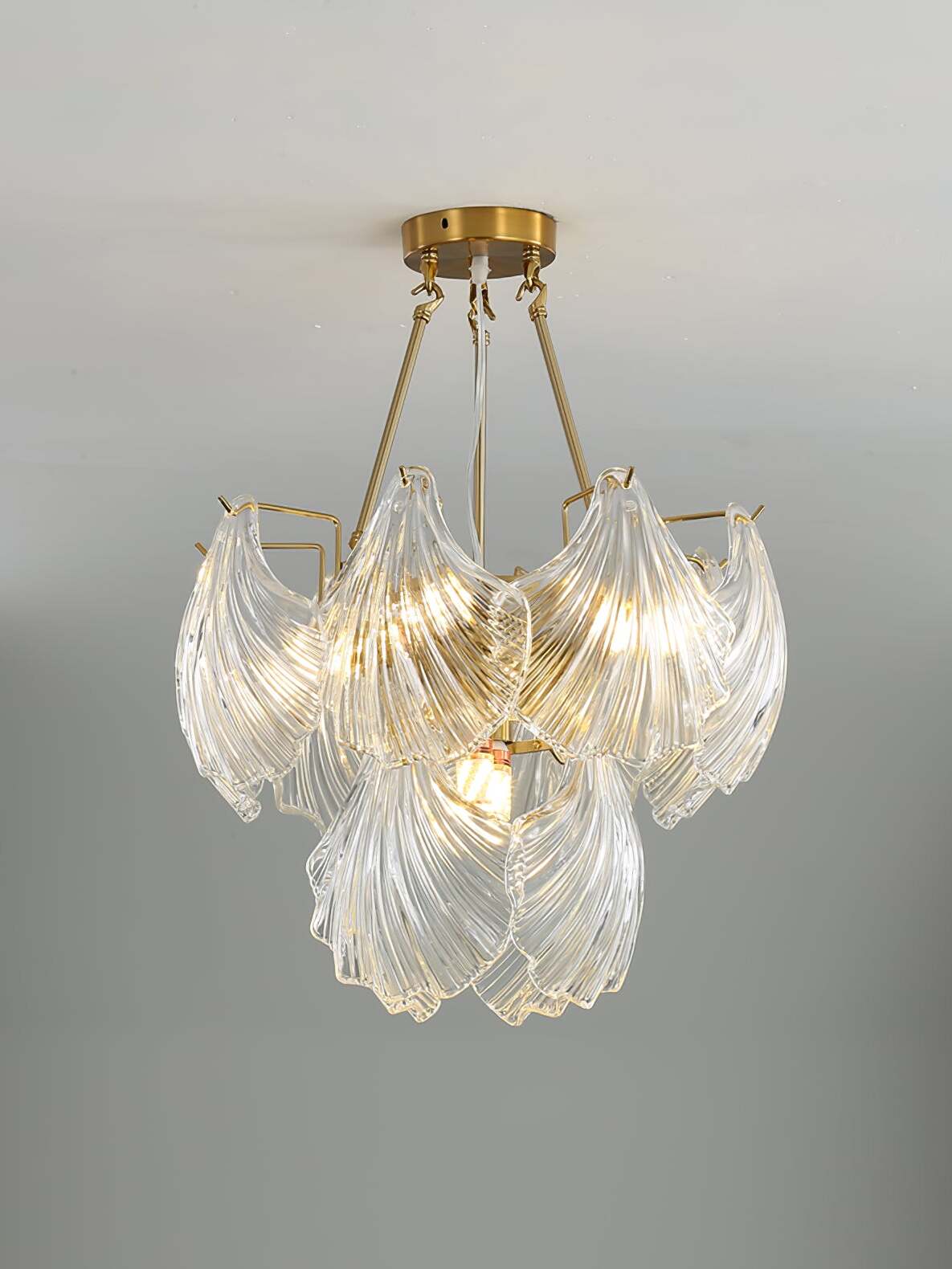 Smaller round shell-panel fixture with gold-tone canopy rods and layered clear glass panels
