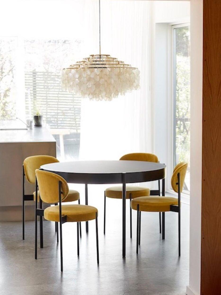 Shell chandelier over a black round dining table