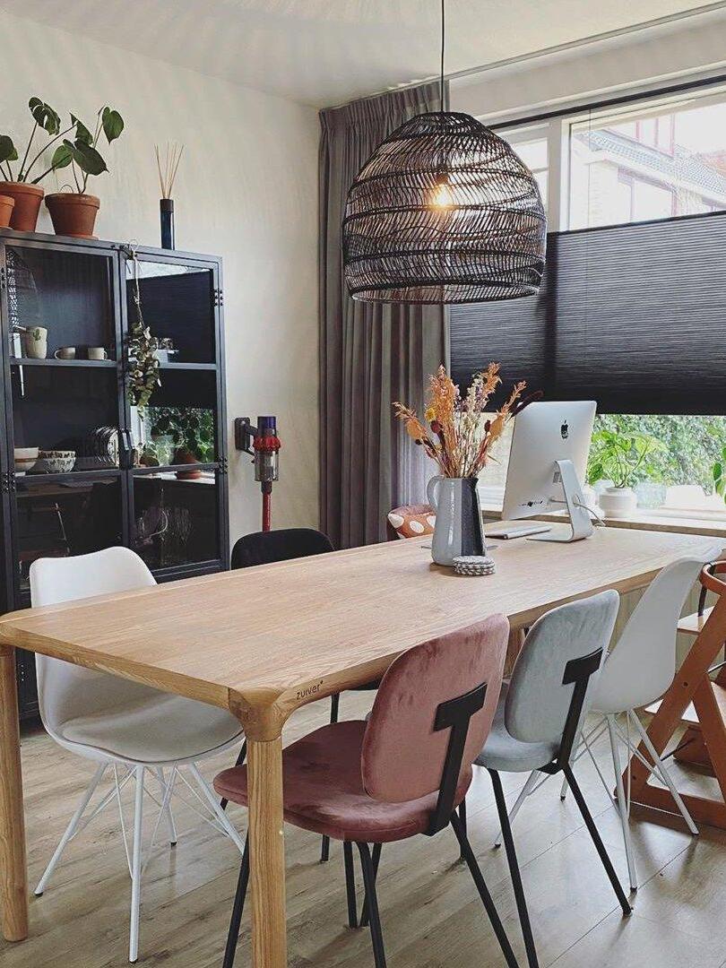 Black basket pendant over a wooden dining table