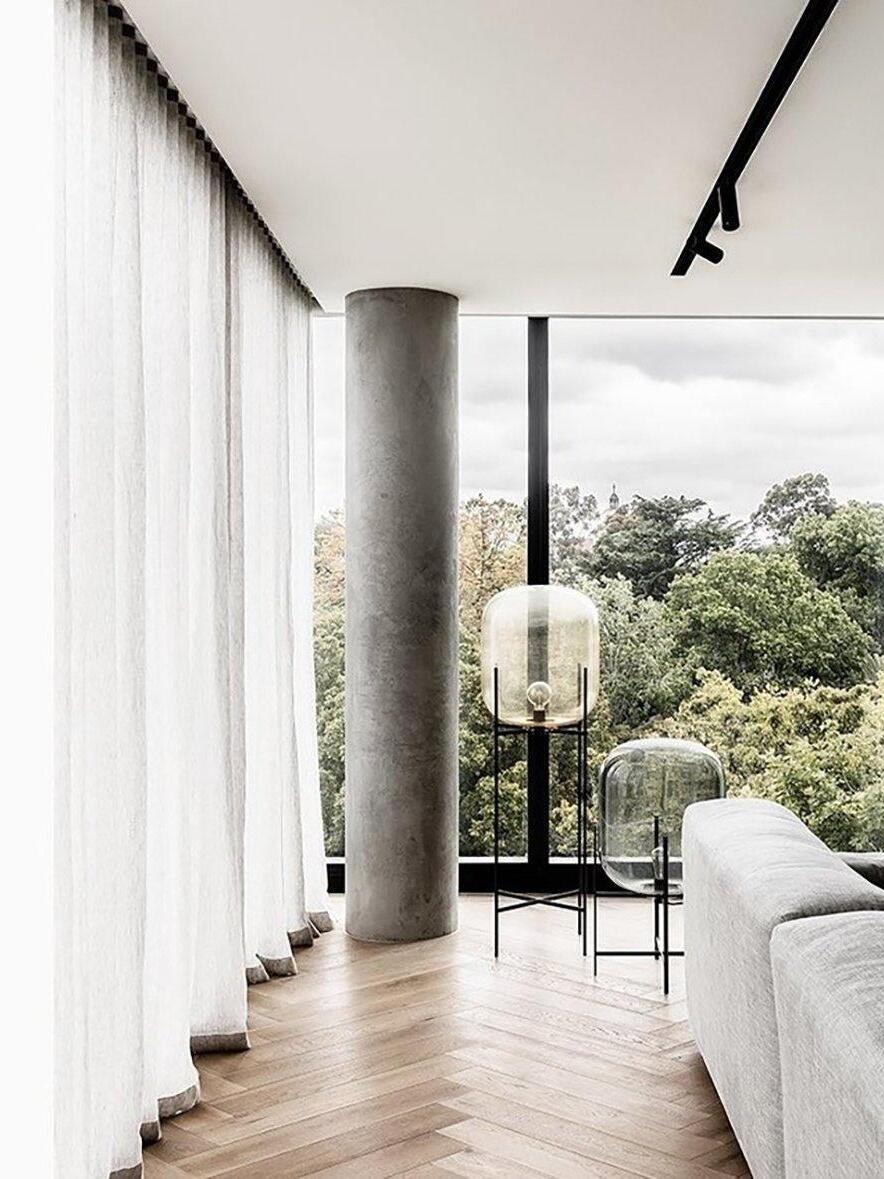 Glass lamps of different heights near a large window overlooking trees.