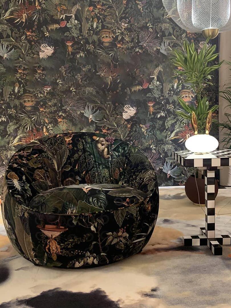 Small rabbit lamp on patterned table beside botanical upholstered chair