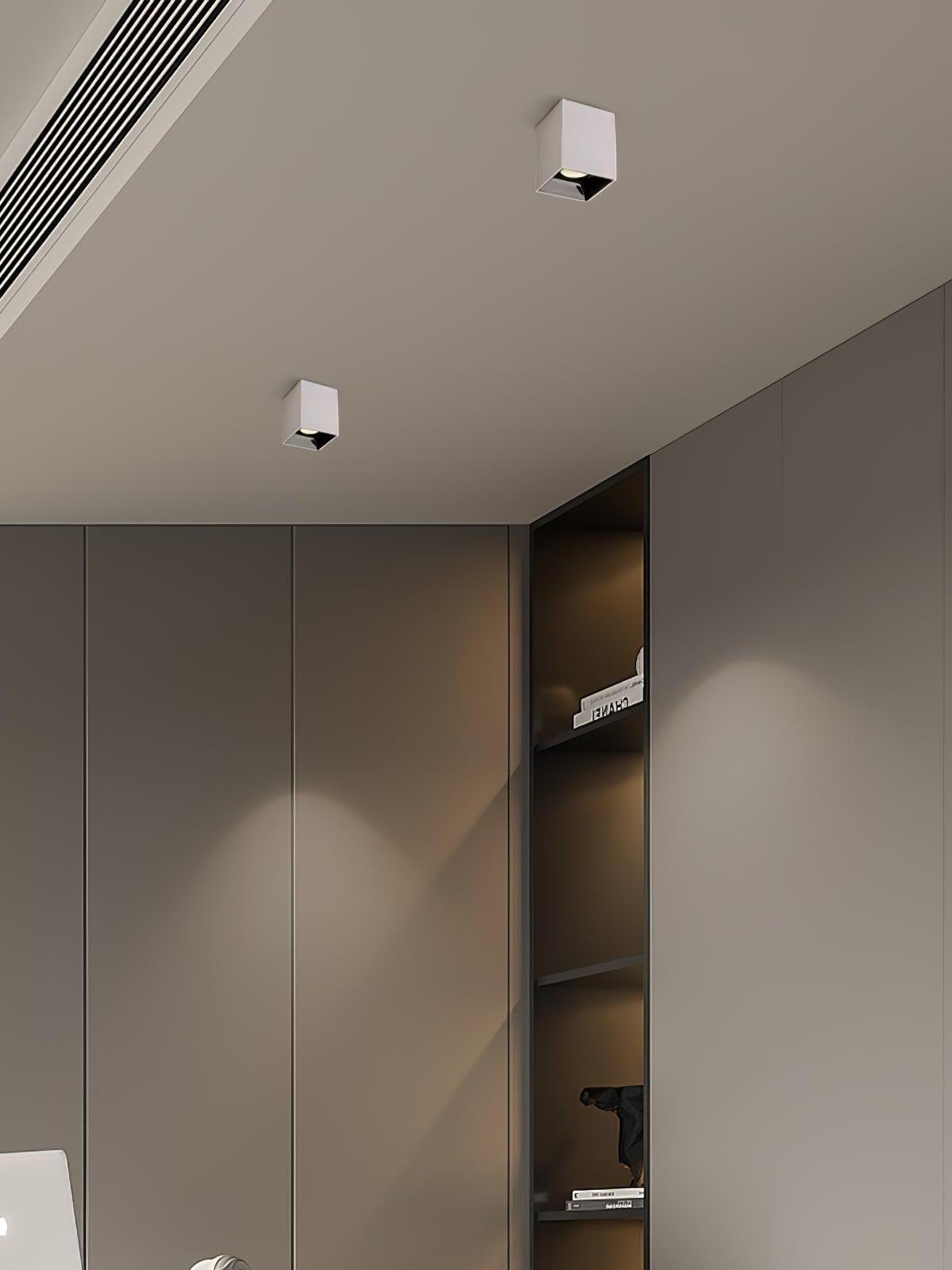 Two white ceiling spots above a gray cabinet wall with open display shelves
