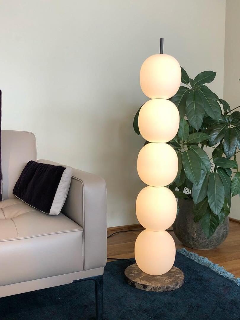 Glowing globe lamp beside sofa and plant