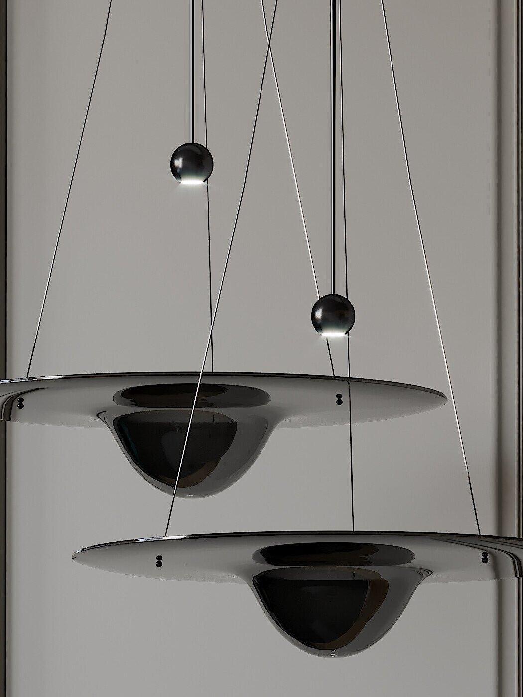 Two clear glass disc pendants against pale wall
