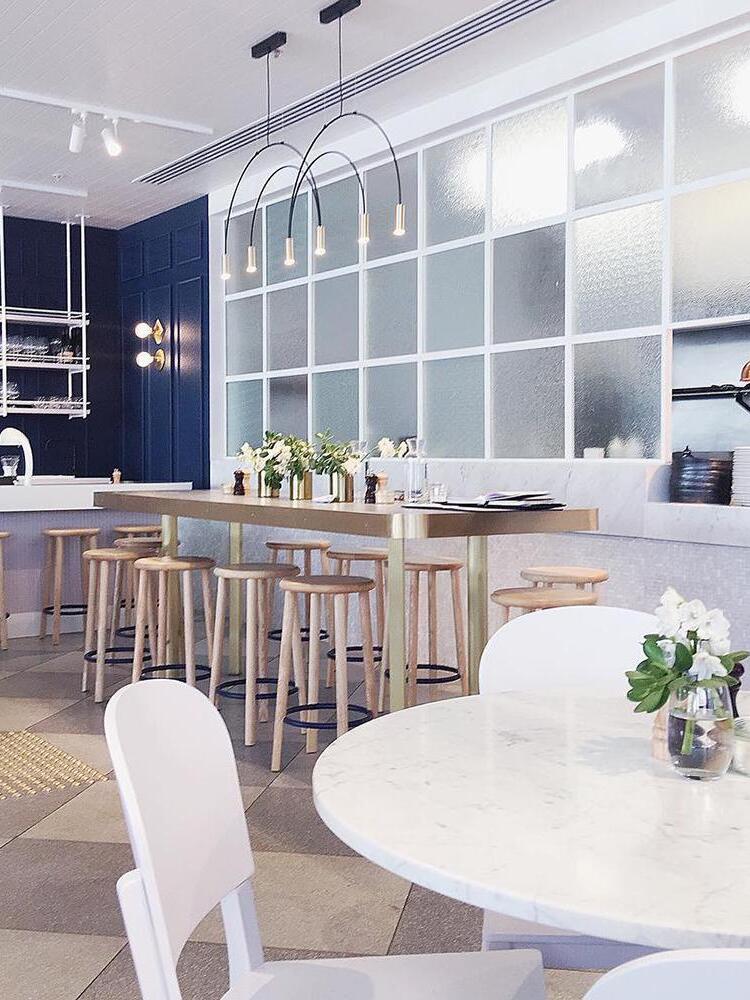 Gold-head arch light in a bright dining interior