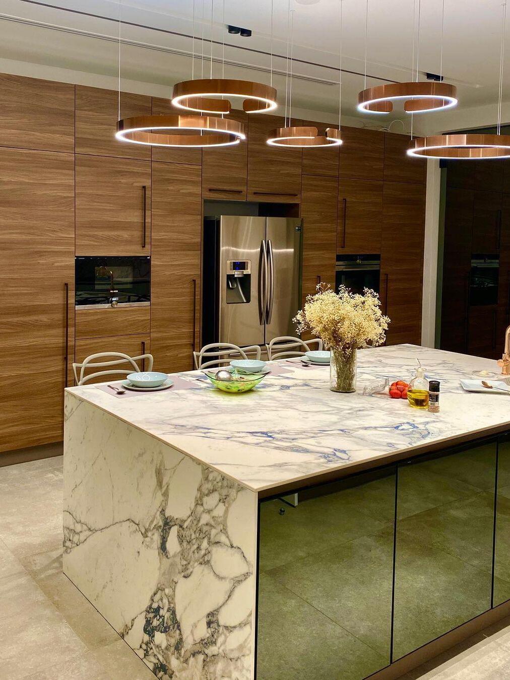 Several gold-coloured rings above a kitchen island