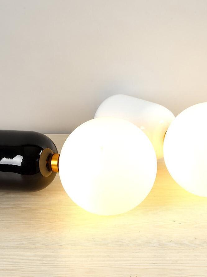 White globes and rounded metal bodies resting on a surface