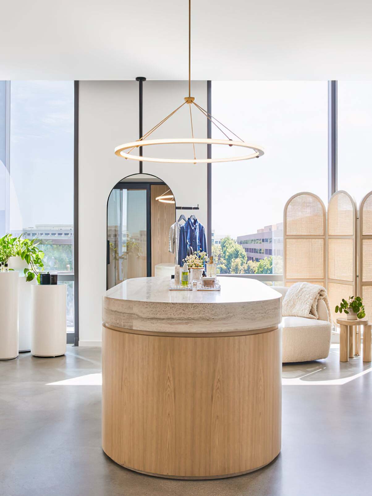 Gold ring pendant above a round island in bright interior