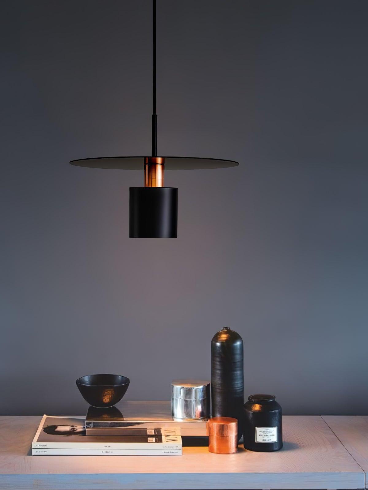 Black metal disc pendant above dark worktop