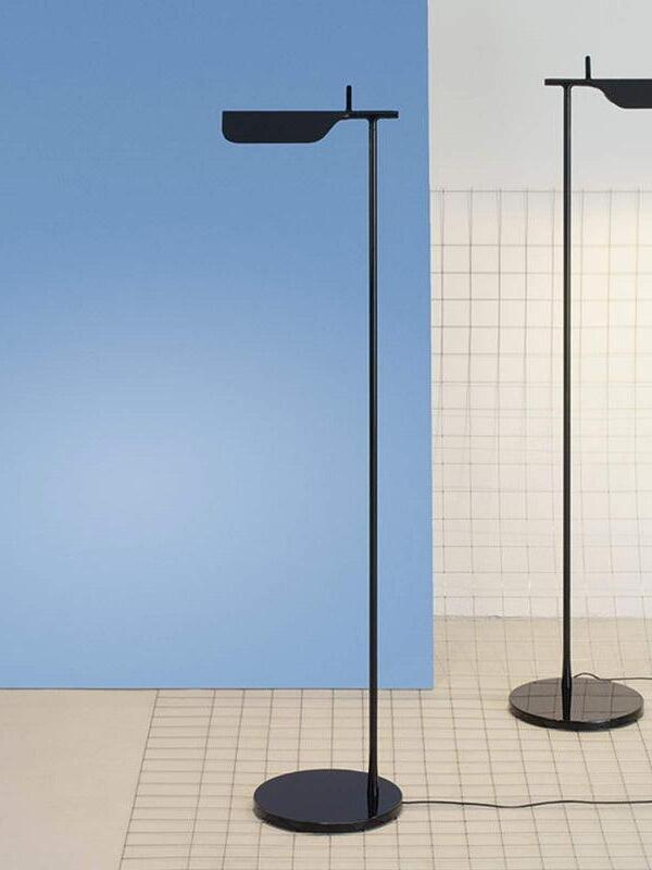 Blue and black floor lamps beside a blue wall