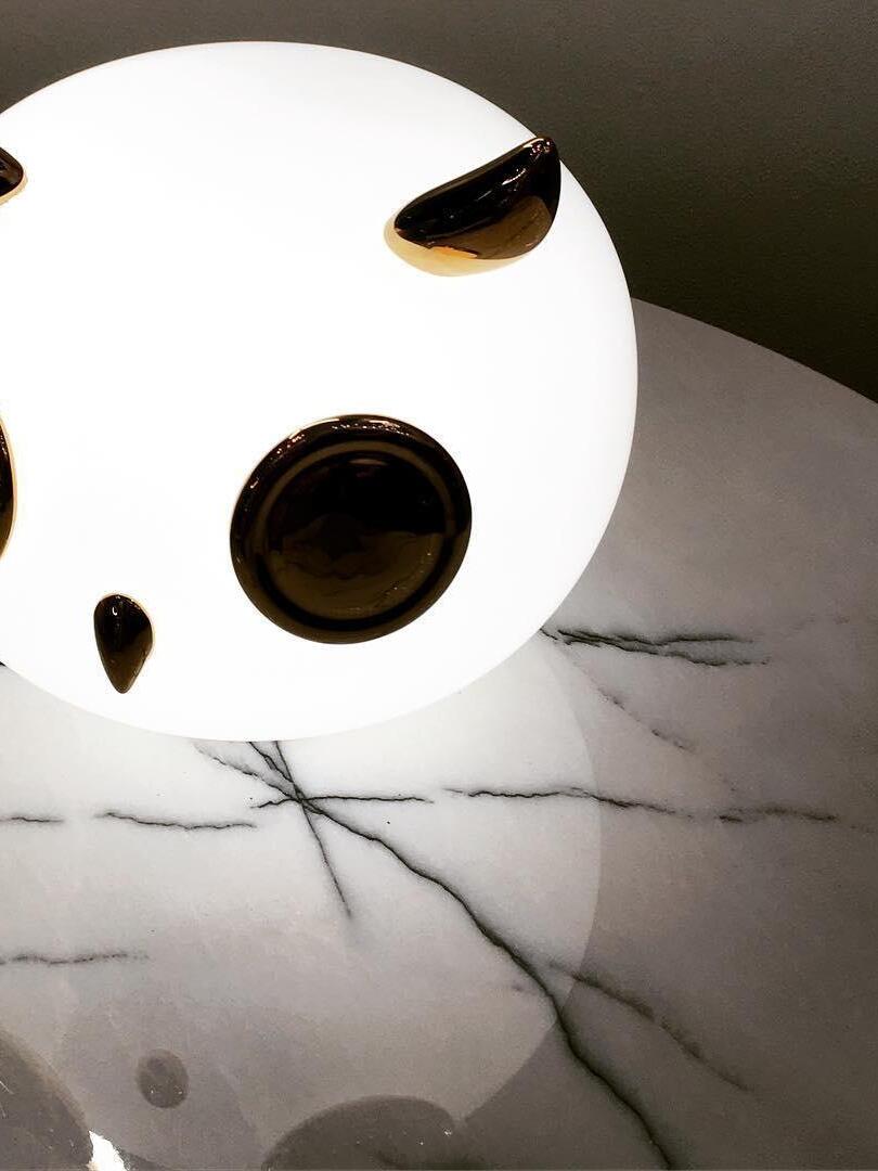 Closer glowing owl face on veined tabletop with gold-tone eye discs
