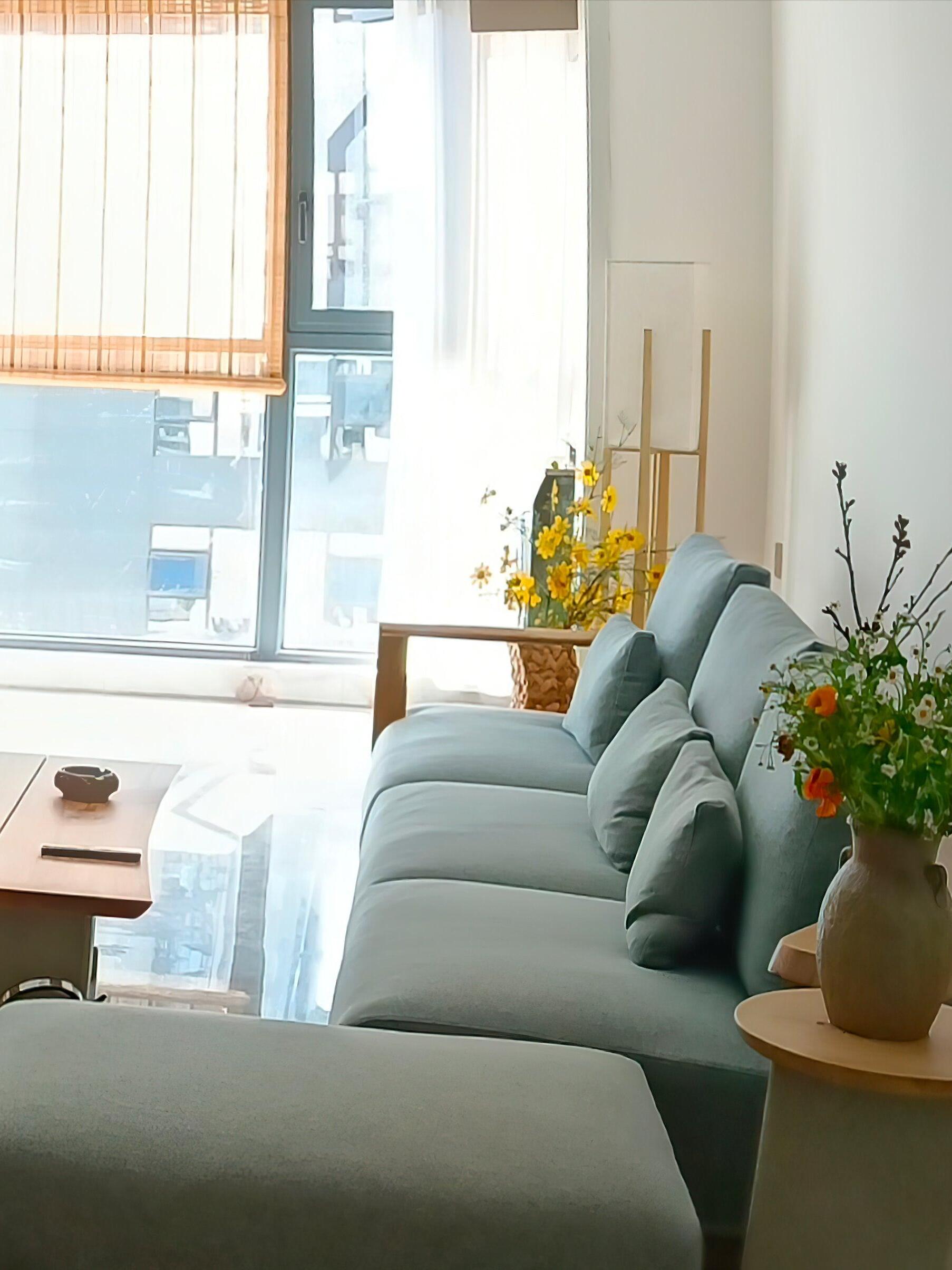 Wood frame lamp beside pale sofa