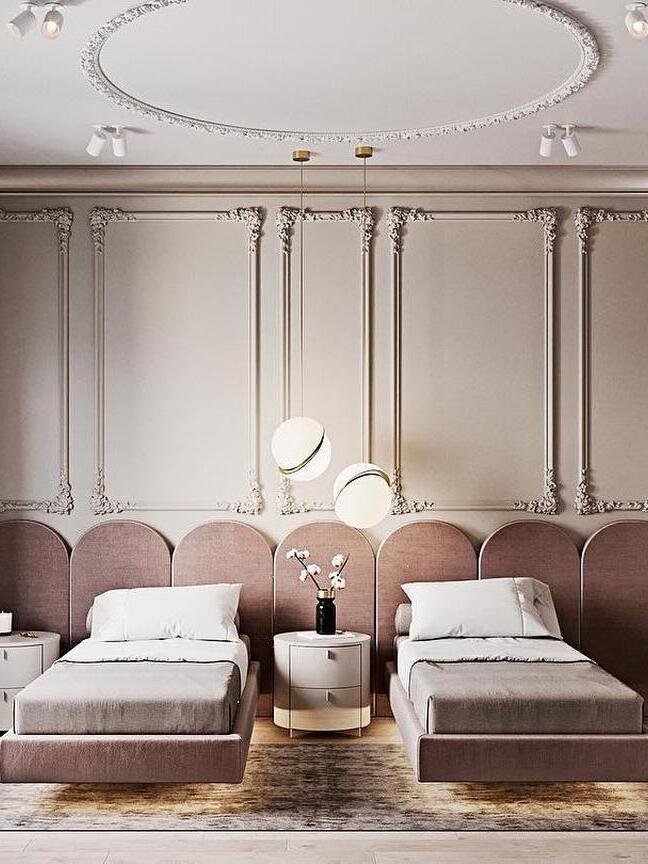 Two separately mounted Crescent globe pendants between upholstered beds and a flower-topped table