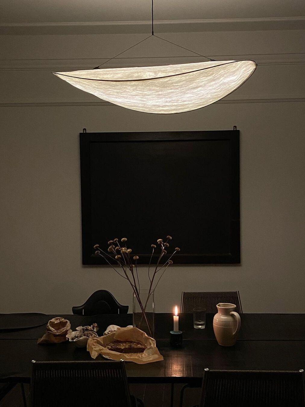 Illuminated pendant above a dark dining corner