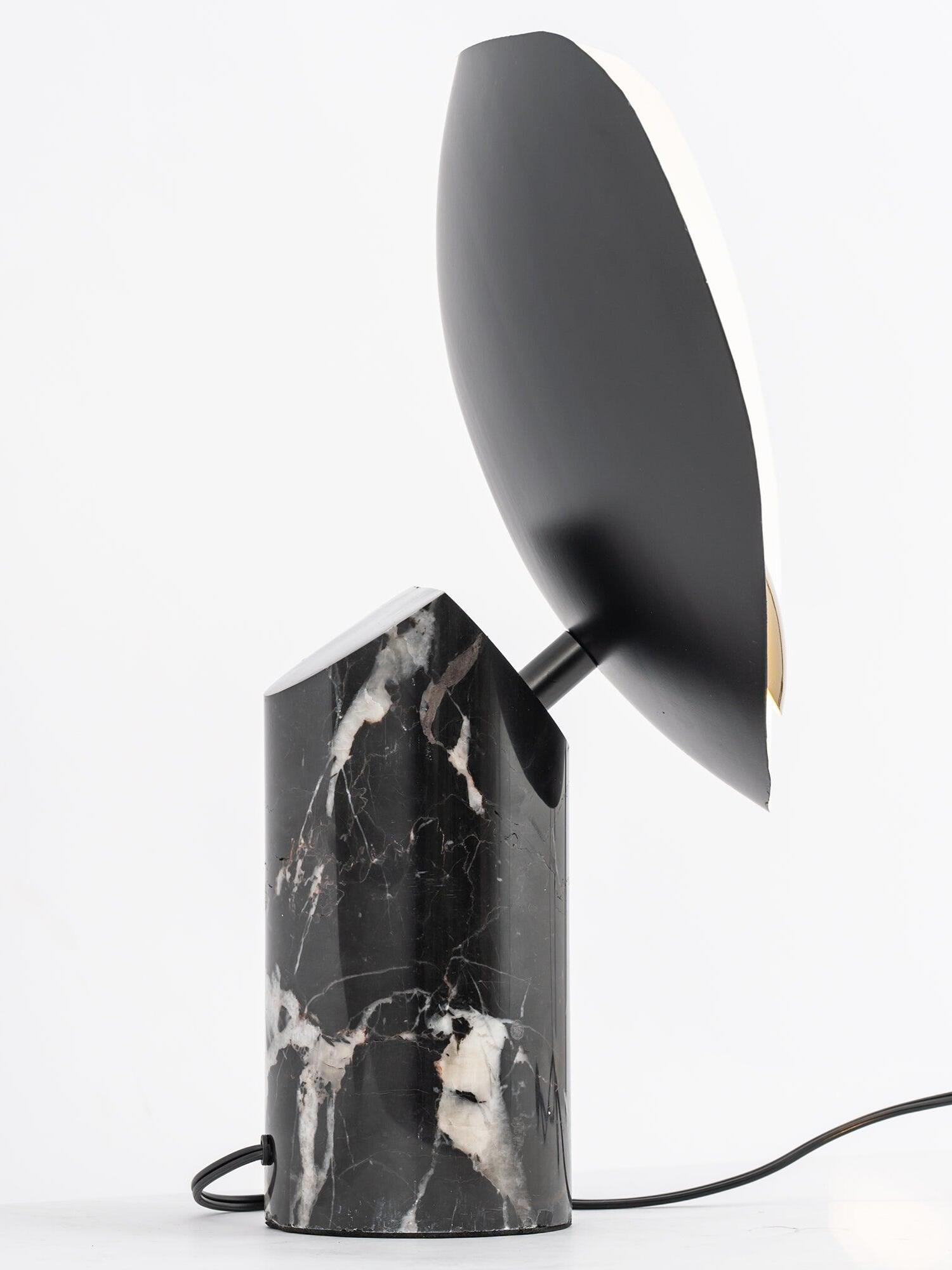 Side of black shade back and veined marble base with cord