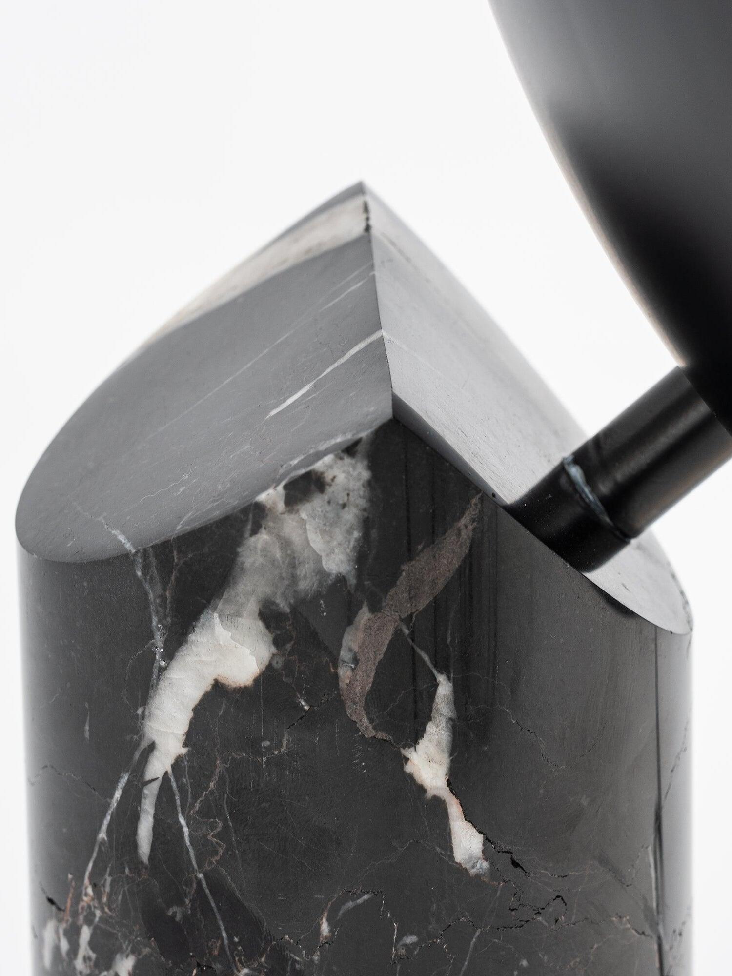 Close slanted top of veined black cylinder and shade stem