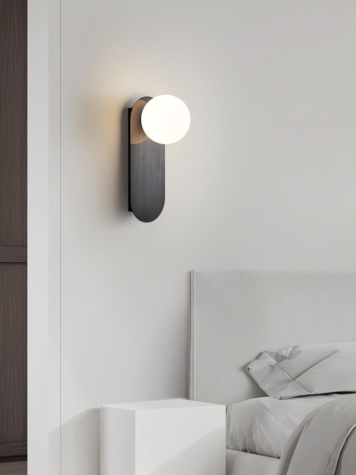 Single Black wall sconce above a bedside position