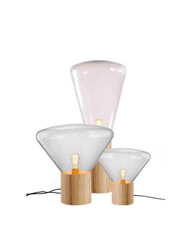 Grouped clear glass lamps with broad and tall narrow shapes on wood bases