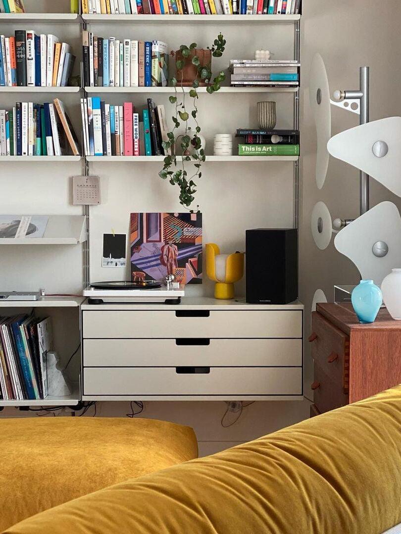 White panel floor lamp beside bookshelves