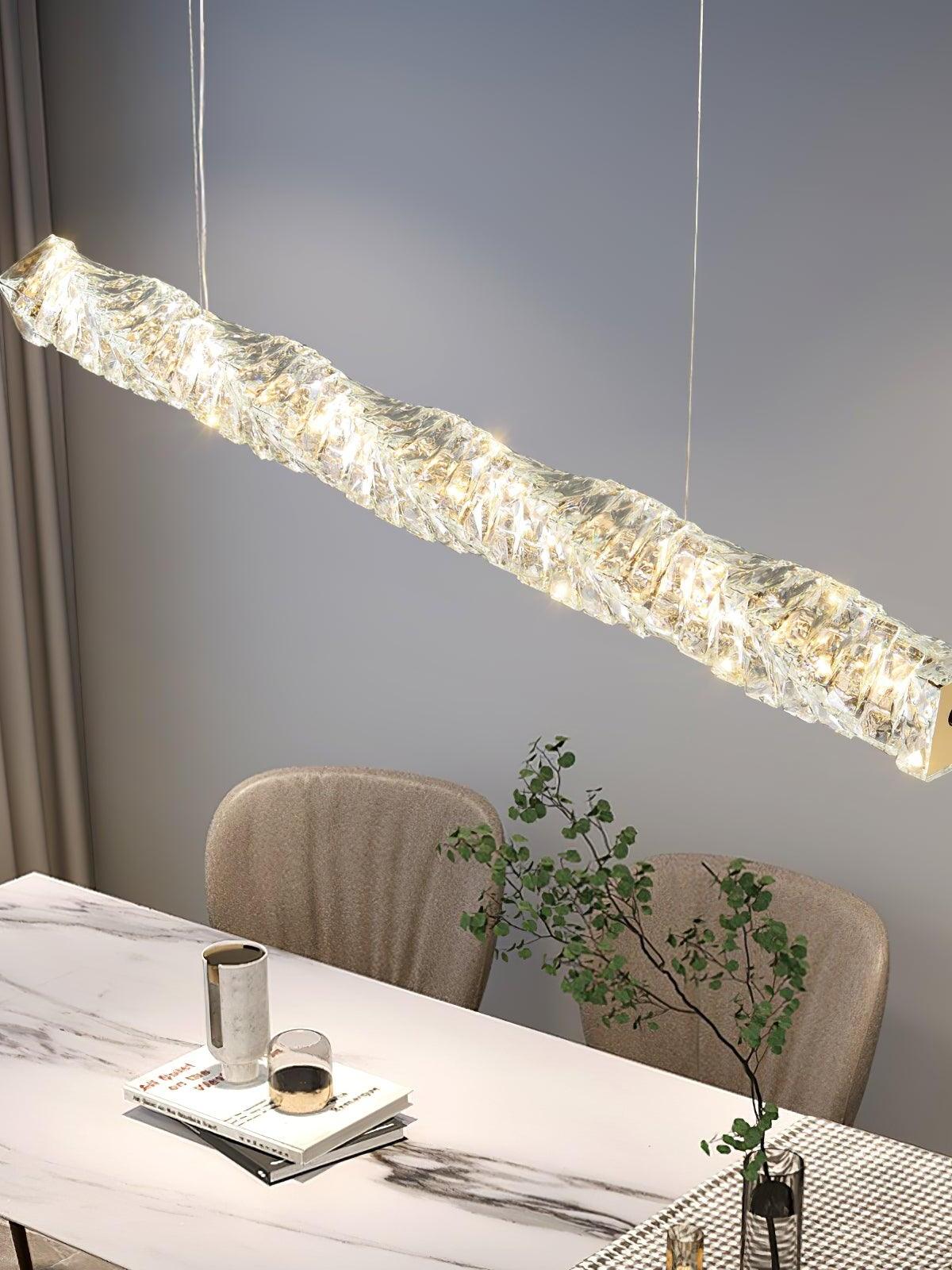 Angled close view of the illuminated crystal bar above a marble dining table and pale upholstered chairs