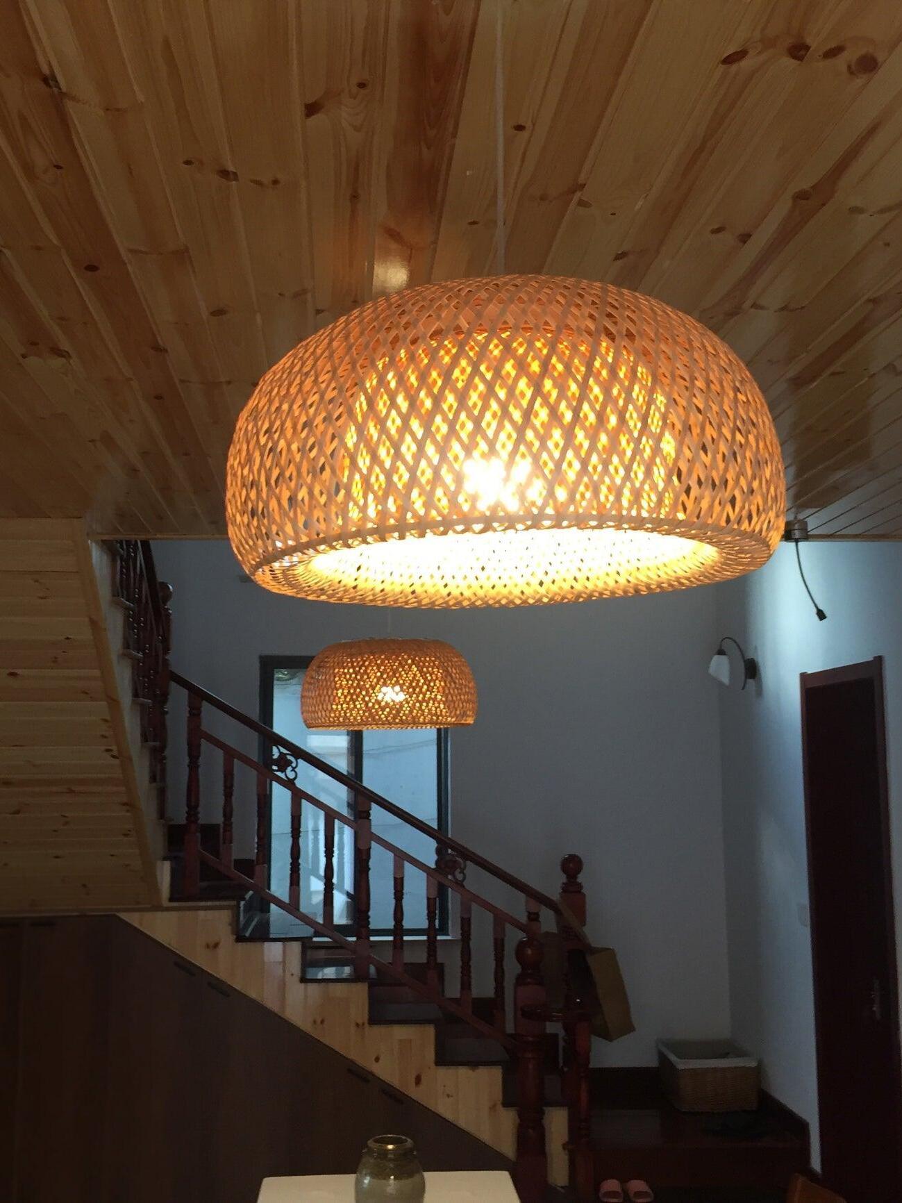 Warm woven pendant under timber ceiling beside stairs