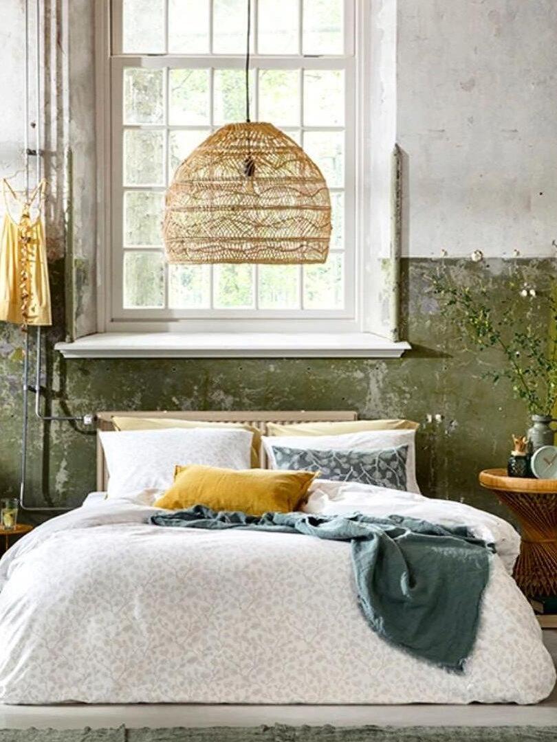 Rattan dome over a bed with colourful cushions