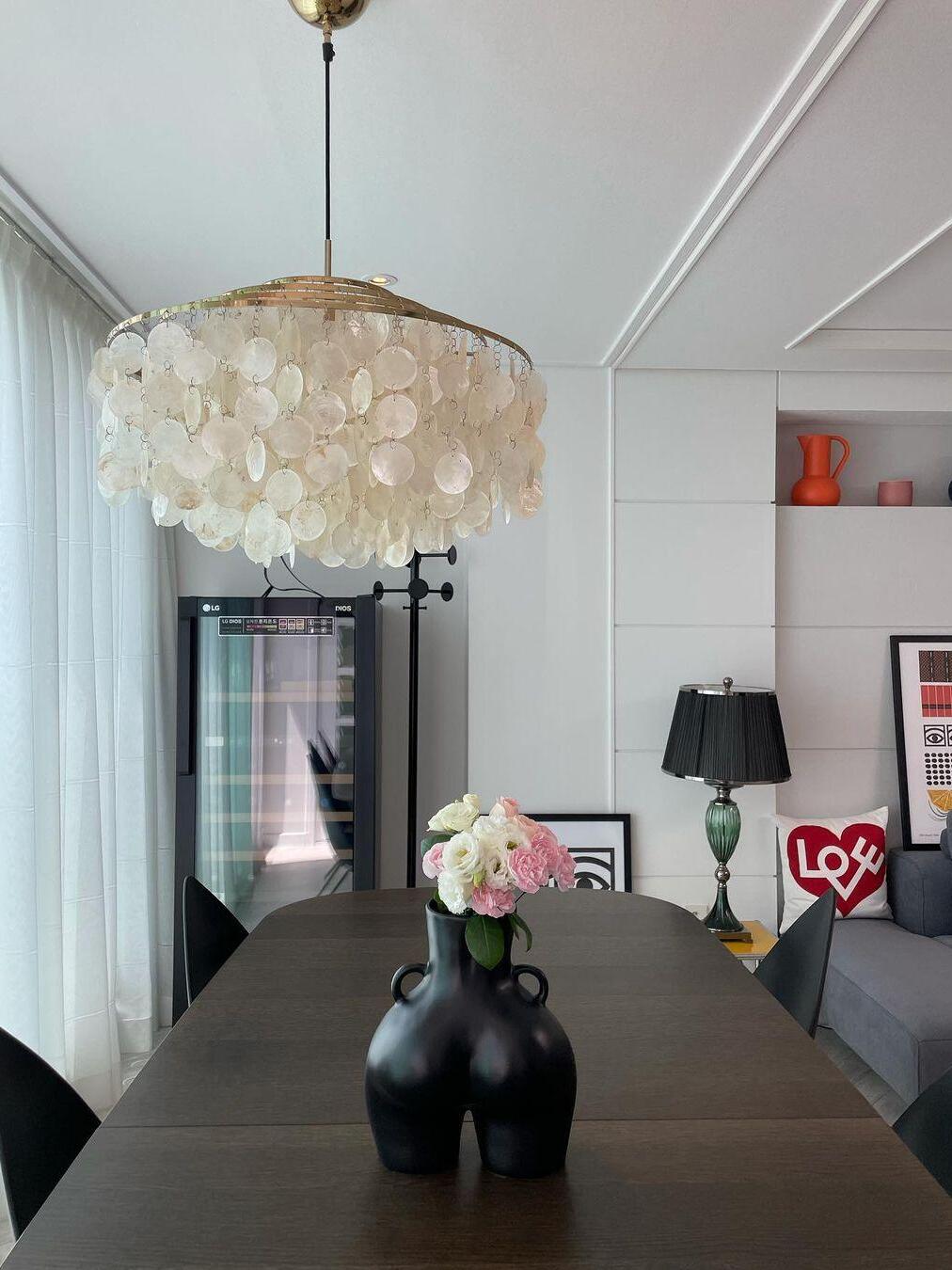 White shell discs above a dark dining table