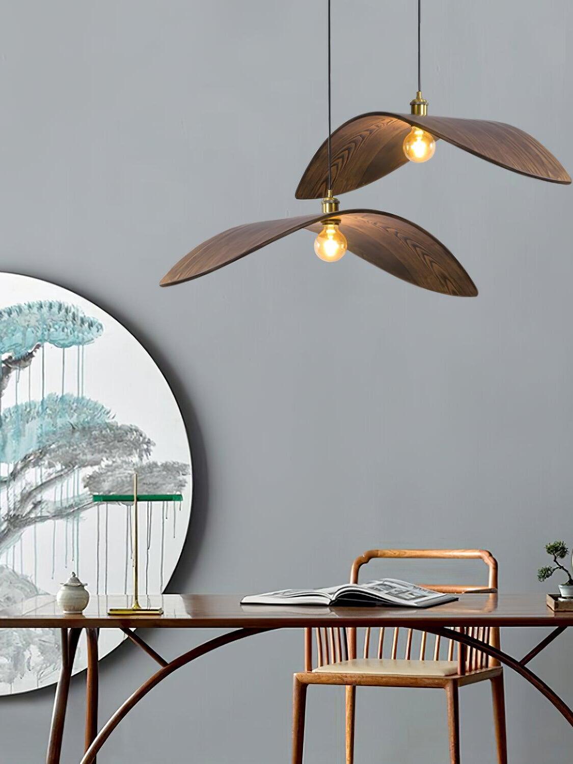 Two curved wooden pendants at different heights above a desk and a round decorative panel