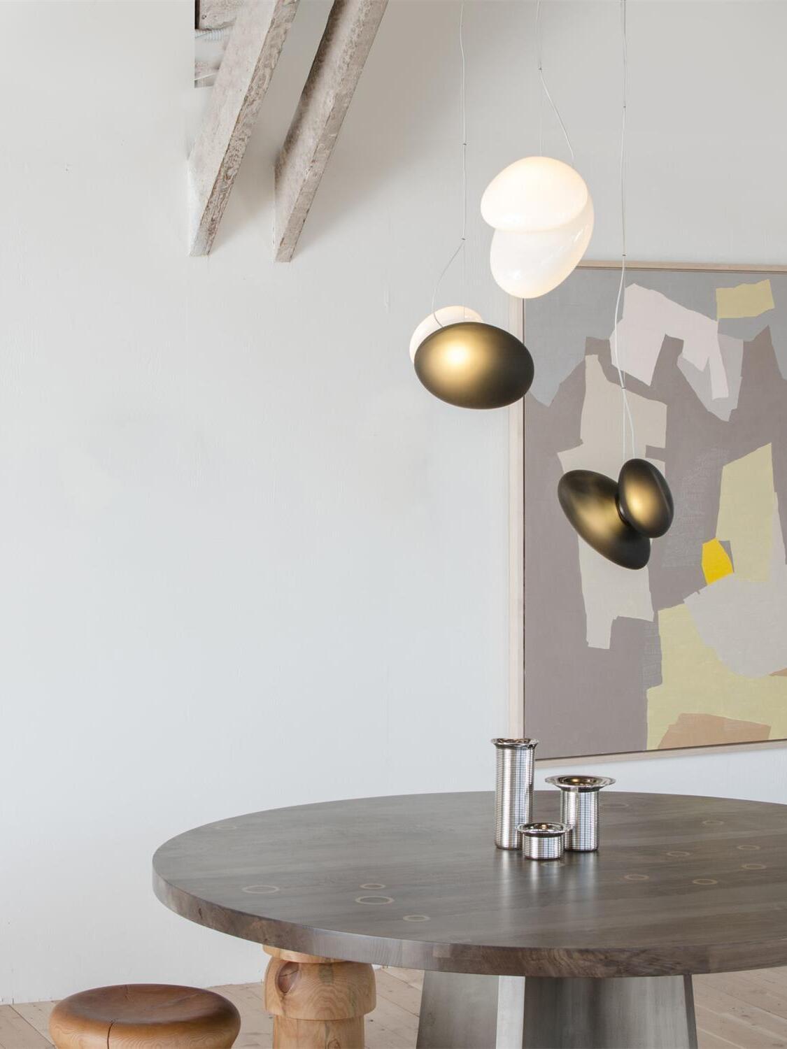 Pebble pendants in white and bronze tones above a round table