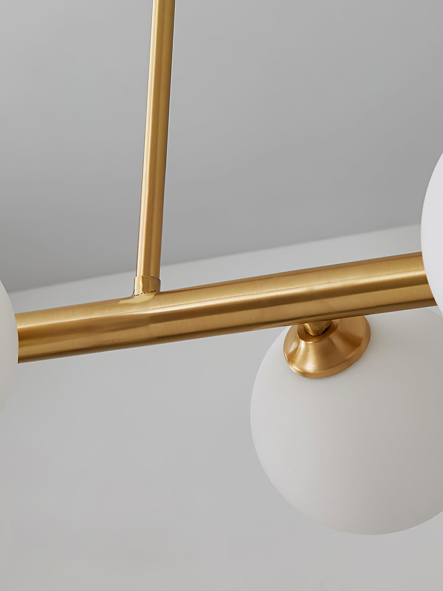 Arteriors brass-tone rod junction and capped attachment above a white glass globe