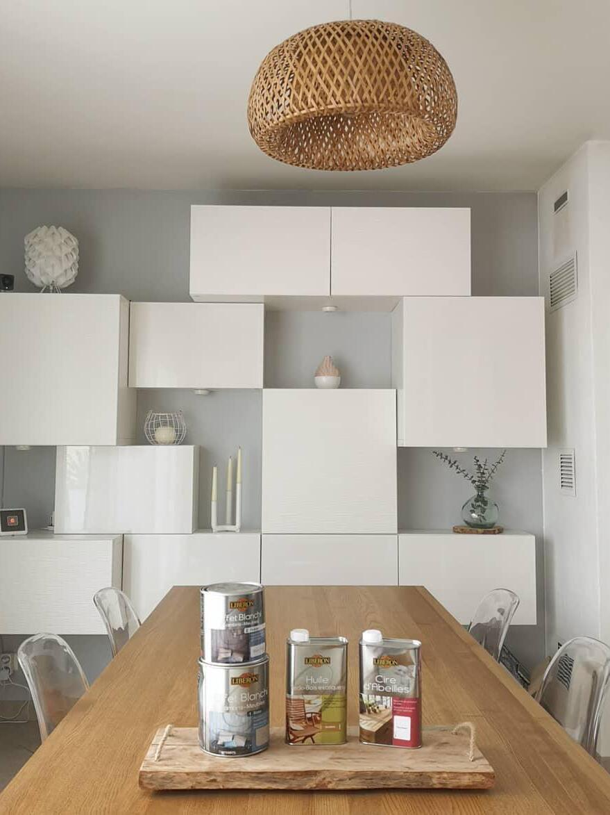 Natural woven pendant above long table in bright kitchen