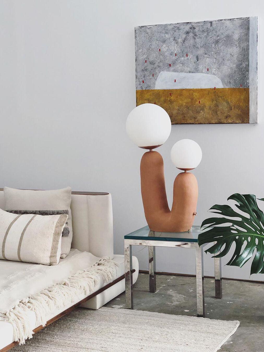 U-shaped table lamp beside a pale sofa