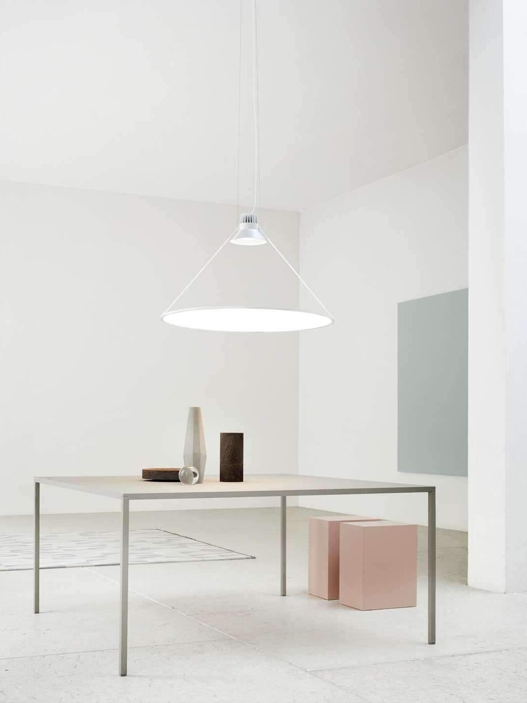 White-looking disc pendant above a simple table