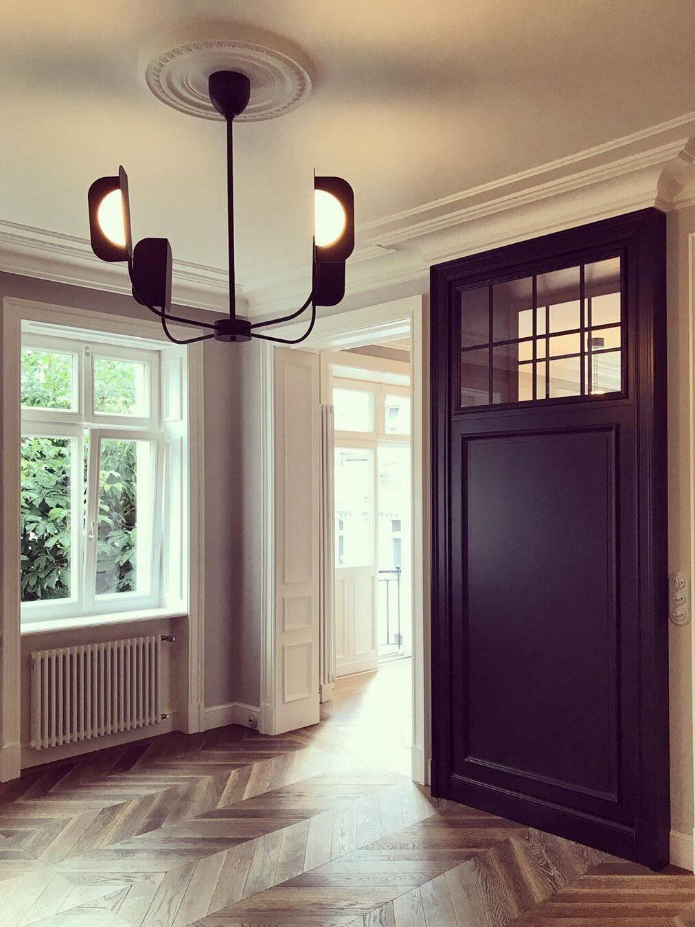 Small black LEAF chandelier in an empty room